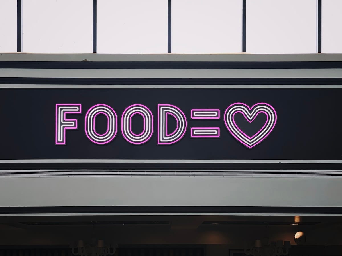 a neon sign that says foodie with a heart