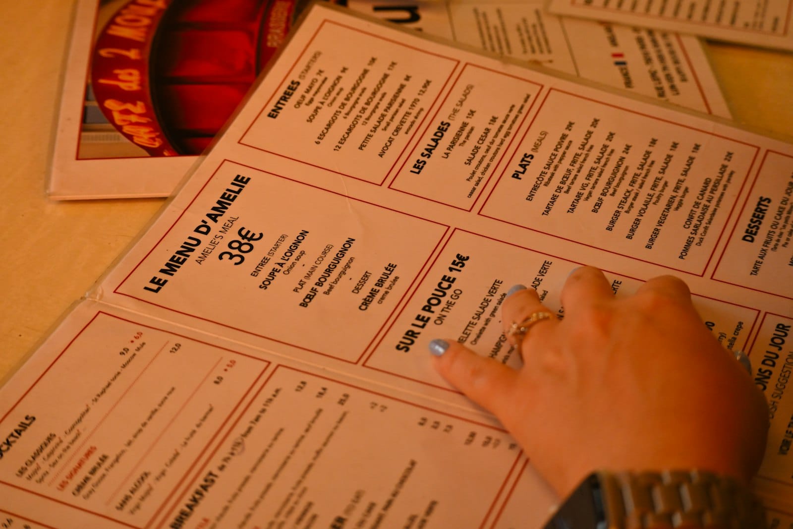 A person's hand on top of a menu